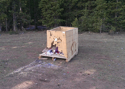 Discarded shipping box filled with trash in Pike National Forest